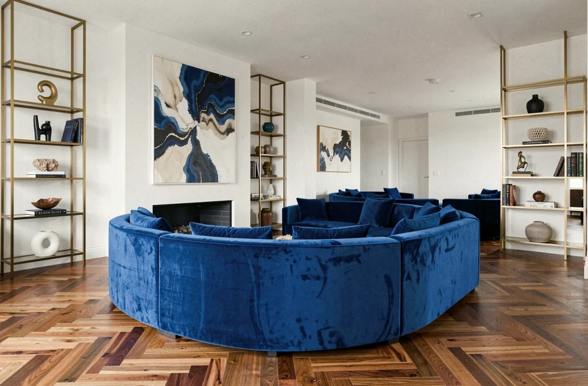 Salon design à Nice avec canapé courbe en velours cobalt, parquet en chevrons et étagères en laiton géométriques