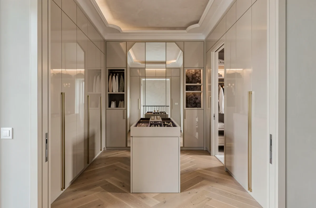 Dressing sur mesure luxueux dans le 06 avec armoires laquées taupe, poignées dorées et parquet en chêne en chevrons